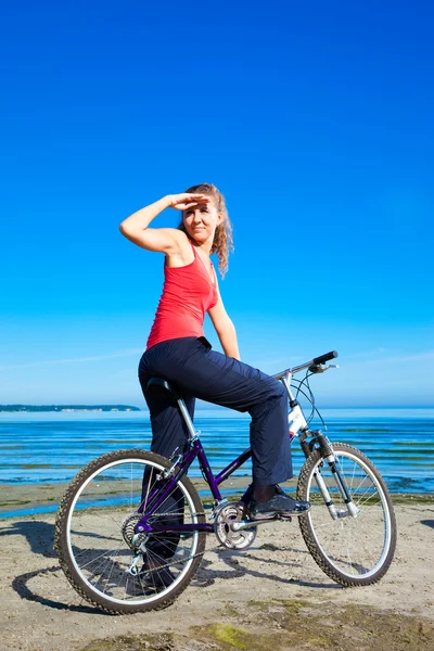 Mulher bonita com bicicleta no mar — Fotografia de Stock