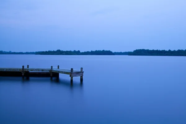 Cais de madeira no lago à noite — Fotografia de Stock