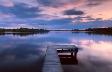 Sunset on lake from the pier clipart