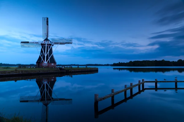 Windmill close to lake at dusk — Stock Photo, Image