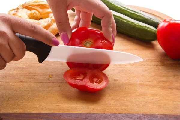 stock image Making of salad of cucumbers and tomatoes in the kitchen