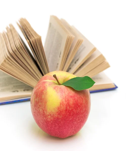 Apfel gegen aufgeschlagenes Buch über weiße Großaufnahme — Stockfoto