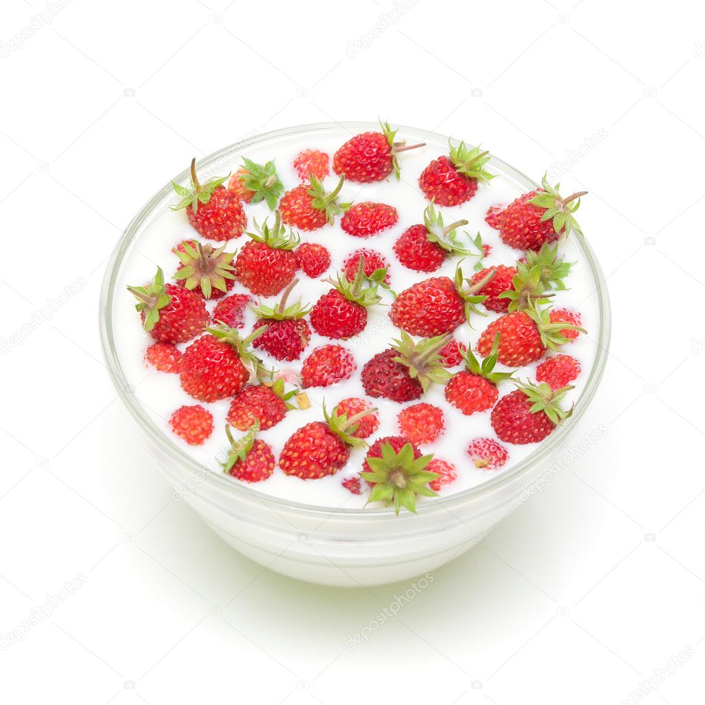 Wild strawberries in a bowl with milk