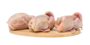 Quail carcasses on a cutting board on a white background clipart