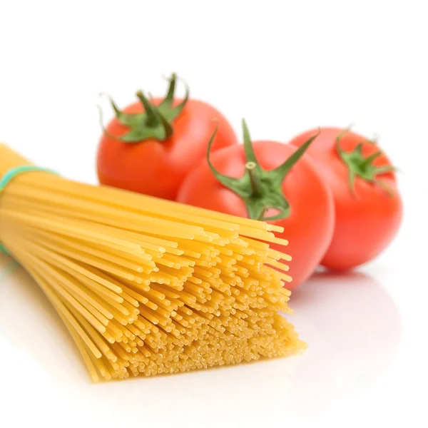 Спагетти и помидоры на белом фоне — стоковое фото
