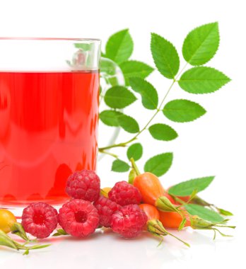 Rosehip berries, raspberries and a cup of tea on a white backgro clipart