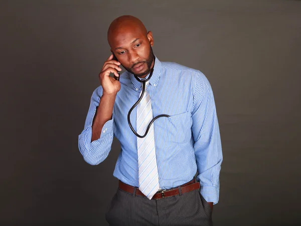Médico afroamericano comprueba su teléfono — Foto de Stock