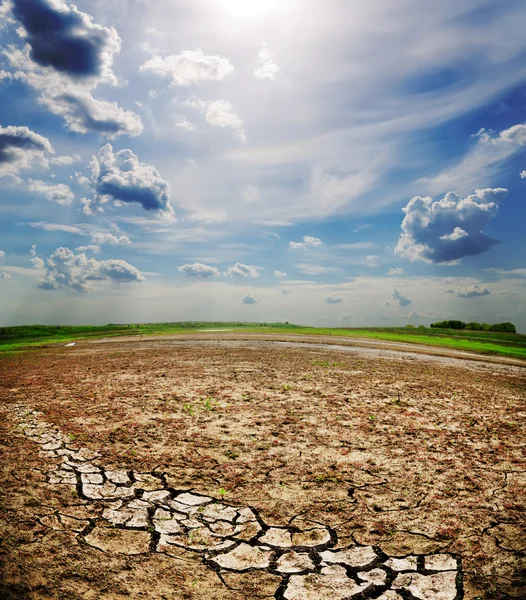 Dramatic sky over dry cracked earth — Stock Photo, Image