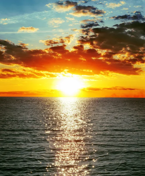 Pôr do sol vermelho sobre a água com ondas — Fotografia de Stock