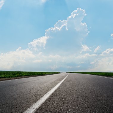 Asphalt road to horizon under cloudy sky clipart