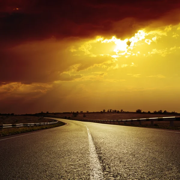 Асфальтовая дорога к драматическому закату — стоковое фото