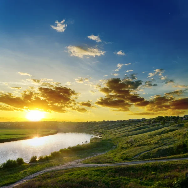 Sun over river with dramatic sky — Stock Photo, Image