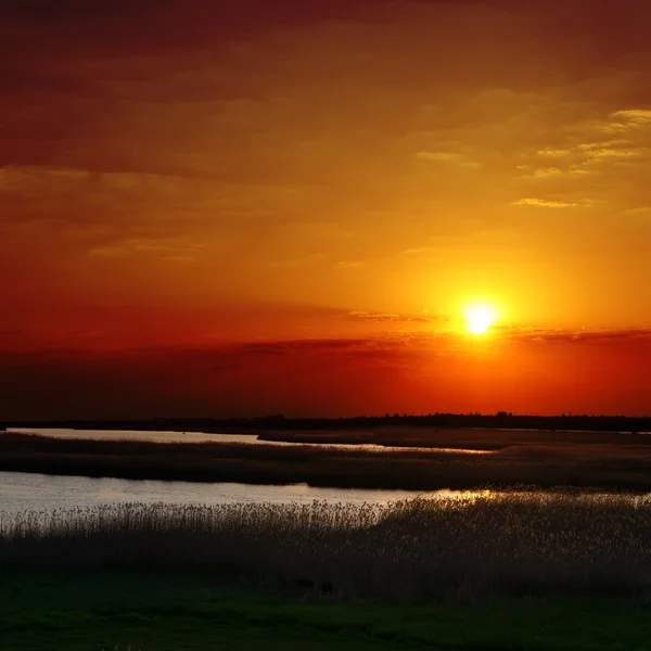 Puesta de sol roja sobre el río — Foto de Stock