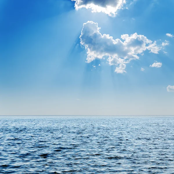 stock image Blue sea and cloudy sky with sun over it