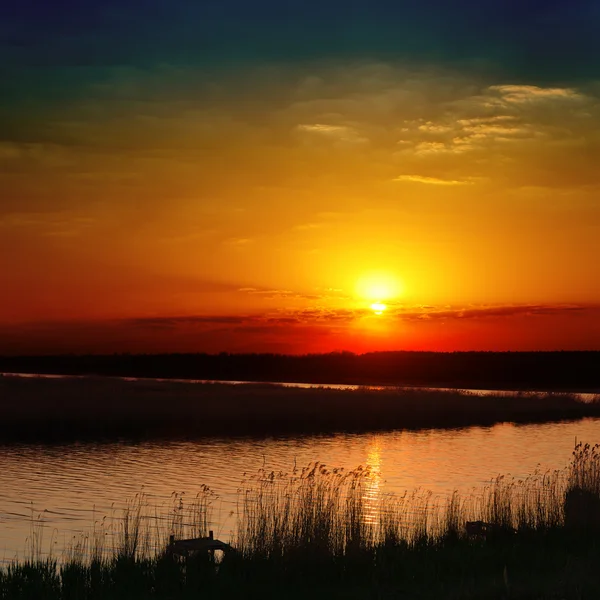 Nehir üzerinde kırmızı günbatımı — Stok fotoğraf