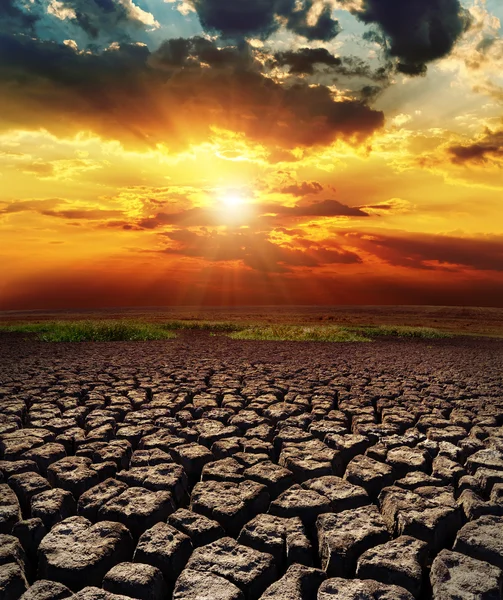 Pôr do sol dramático sobre a terra seca — Fotografia de Stock