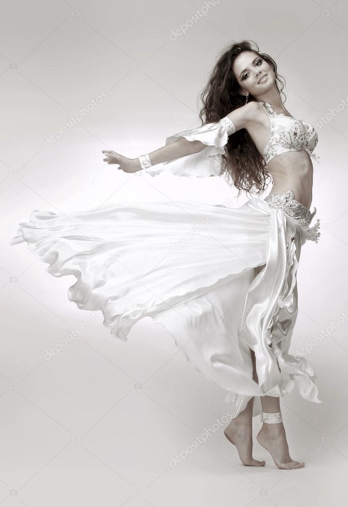 Beautiful young belly dancer wearing white dress