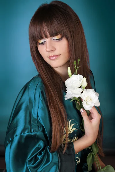 Krásná žena s dlouhými vlasy Stránka s obrázky od a květinami v ruce — Stock fotografie
