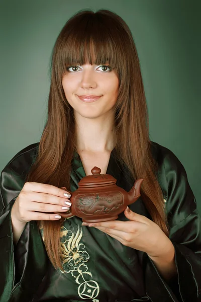 Zelený čaj obřad šťastná žena s konvici na rukou nad zelená — Stock fotografie