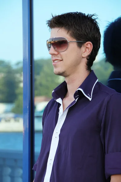 Fashion portrait of the young beautiful man in sunglasses — Stock Photo, Image
