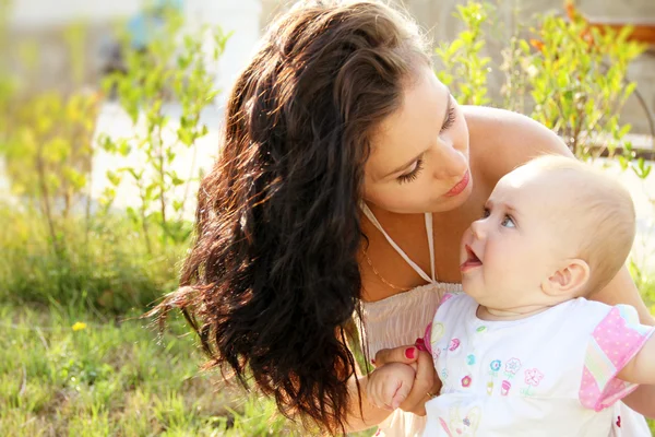 Moeder kuste haar lieve baby, openlucht portret — Stockfoto