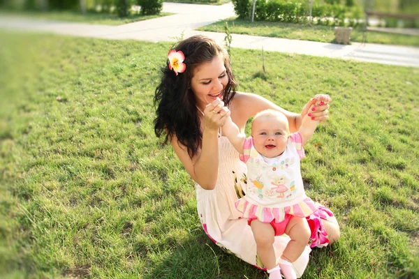 Lachende moeder en baby spelen in park — Stockfoto