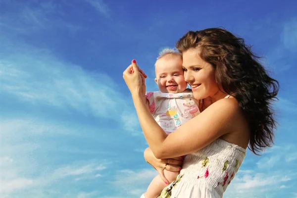 Mutlu anne ile bebek mavi gökyüzü üzerinde — Stok fotoğraf