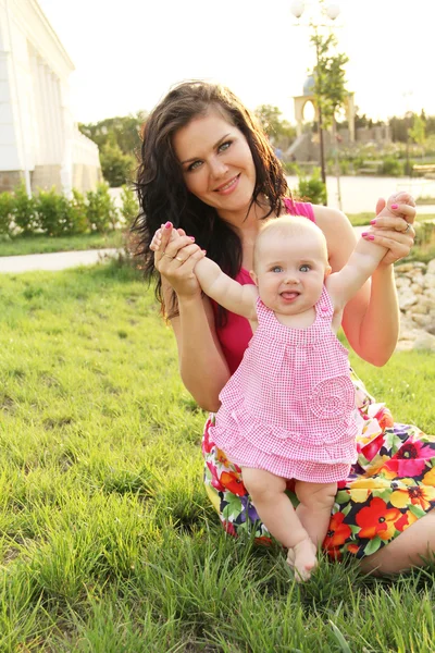 Glückliches Baby macht erste Schritte mit Hilfe der Mutter — Stockfoto