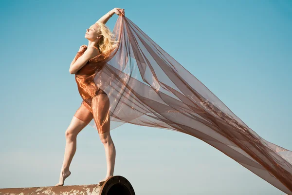 Дівчина танцює з великою помаранчевою тканиною — стокове фото