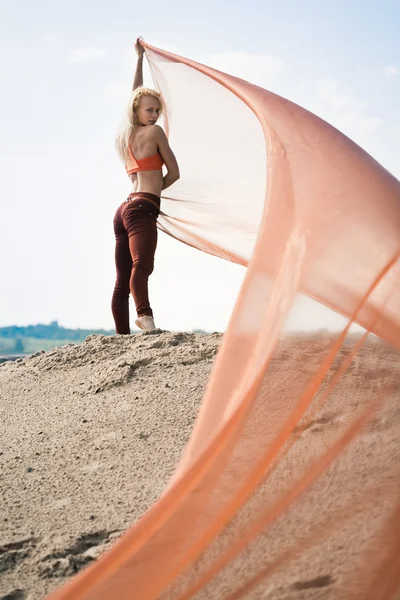 Дівчина танцює з великою помаранчевою тканиною — стокове фото