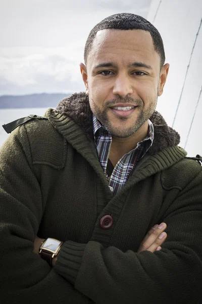 Junger schwarzer Mann mit verschränkten Armen auf dem Bootsdeck — Stockfoto