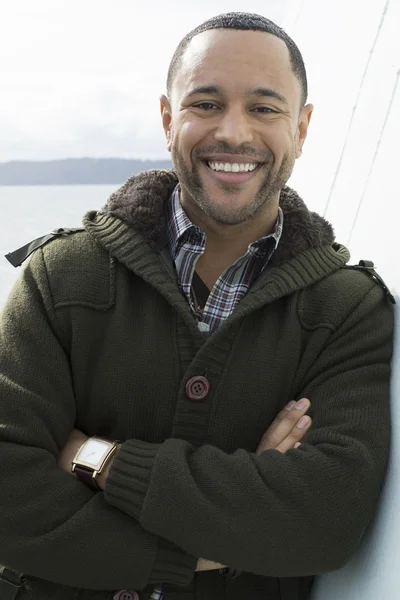 Jonge zwarte man op het dek van de boot Stockafbeelding