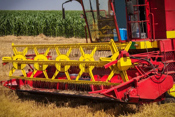 Harvester op een tarweveld combineren met een blauwe hemel — Stockfoto