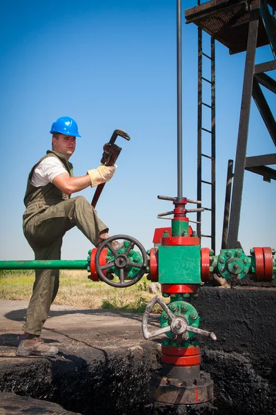 Нефтяники проверяют нефтяной насос — стоковое фото