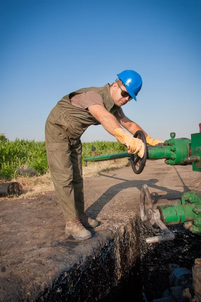 Olja worker kontrollera oljepumpen — Stockfoto