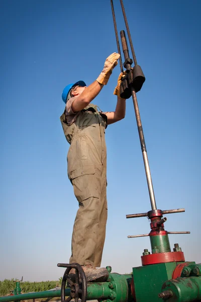 Trabajador de aceite comprobar bomba de aceite —  Fotos de Stock