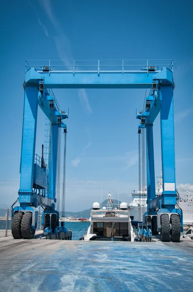 Crane lifting boats at harbor — Stock Photo, Image