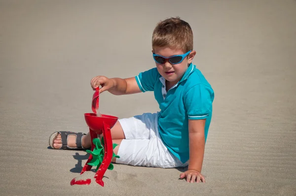 Menino adorável brincando na praia de areia — Fotografia de Stock