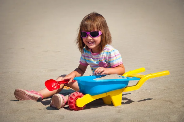 Αξιολάτρευτο κοριτσάκι με παιχνίδια στην παραλία στις διακοπές — Φωτογραφία Αρχείου