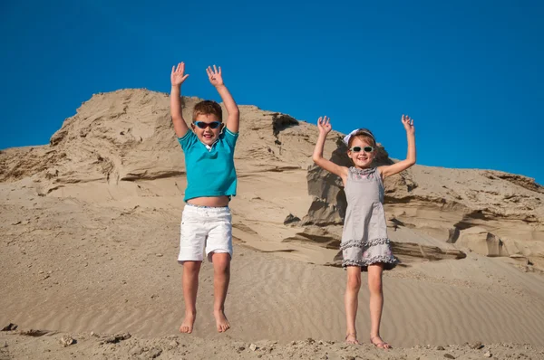 Rozkošná holčička a kluk hraje na písečné pláži — Stock fotografie