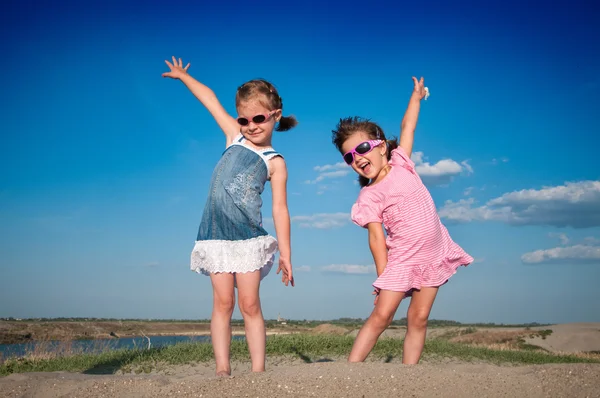 Dvě malé holčičky na písečné pláži — Stock fotografie