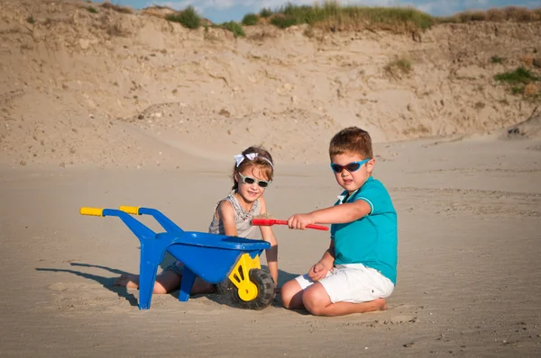 Sevimli küçük kız ve erkek kumsalda oynarken — Stok fotoğraf