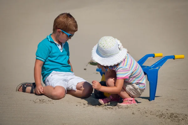 Adorable niña y niño jugando en la playa de arena —  Fotos de Stock