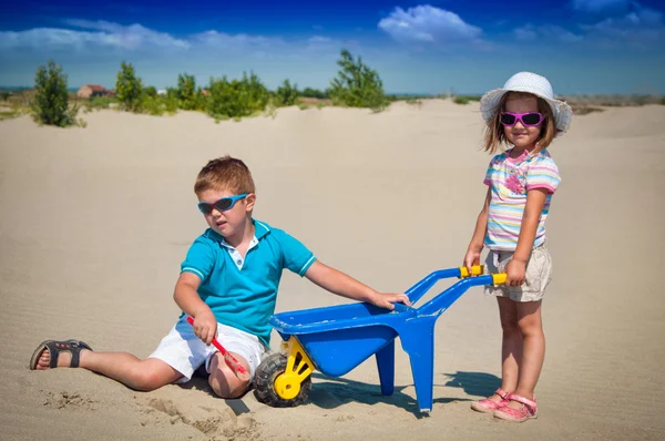 愛らしい少女と少年の砂浜のビーチでのプレー — ストック写真