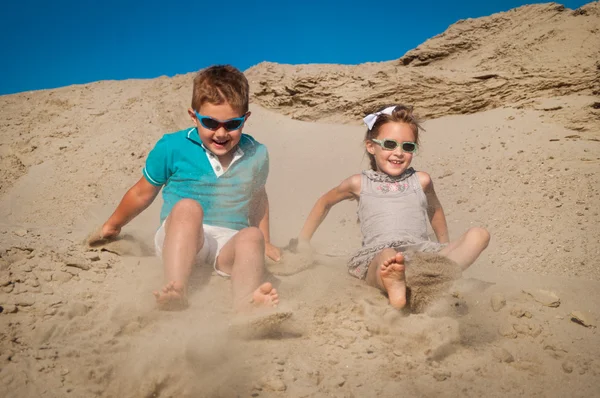 Entzückende kleine Mädchen und Jungen spielen am Sandstrand — Stockfoto
