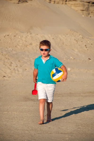 Очаровательный мальчик играет на песчаном пляже — стоковое фото
