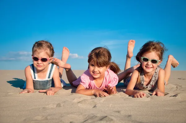 Rozkošný tři malá holčička hraje na písečné pláži — Stock fotografie