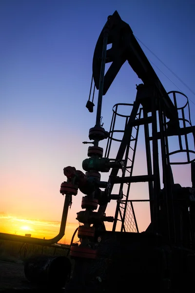 石油泵杰克倒映的落山的太阳 — 图库照片