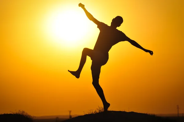 Muž v západu slunce skok — Stock fotografie