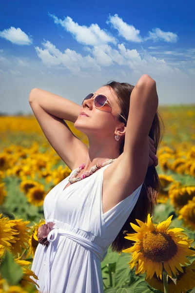 Junge Frau im Schönheitsfeld mit Sonnenblumen — Stockfoto
